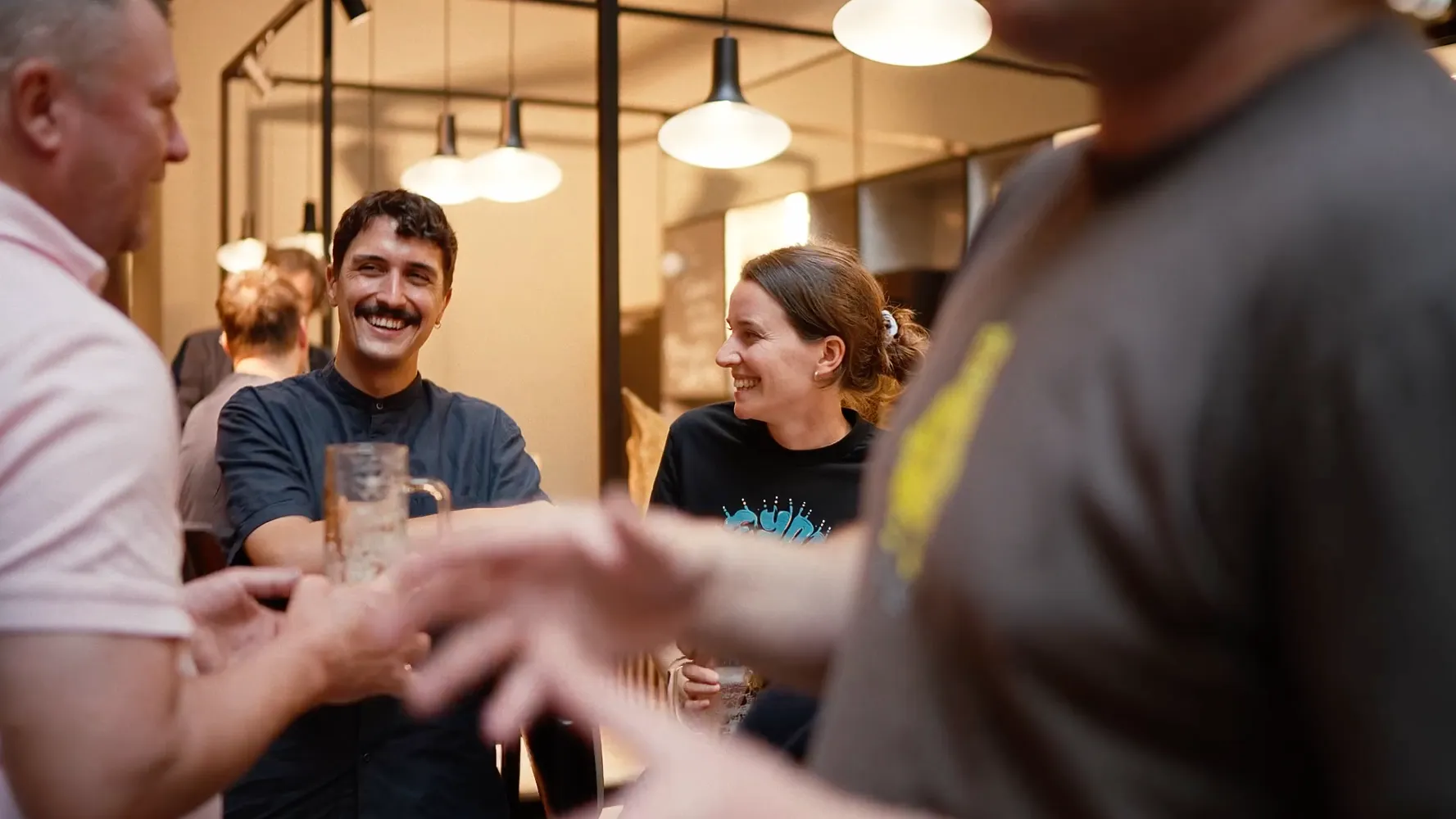 People laughing and clinking glasses together after a conference day