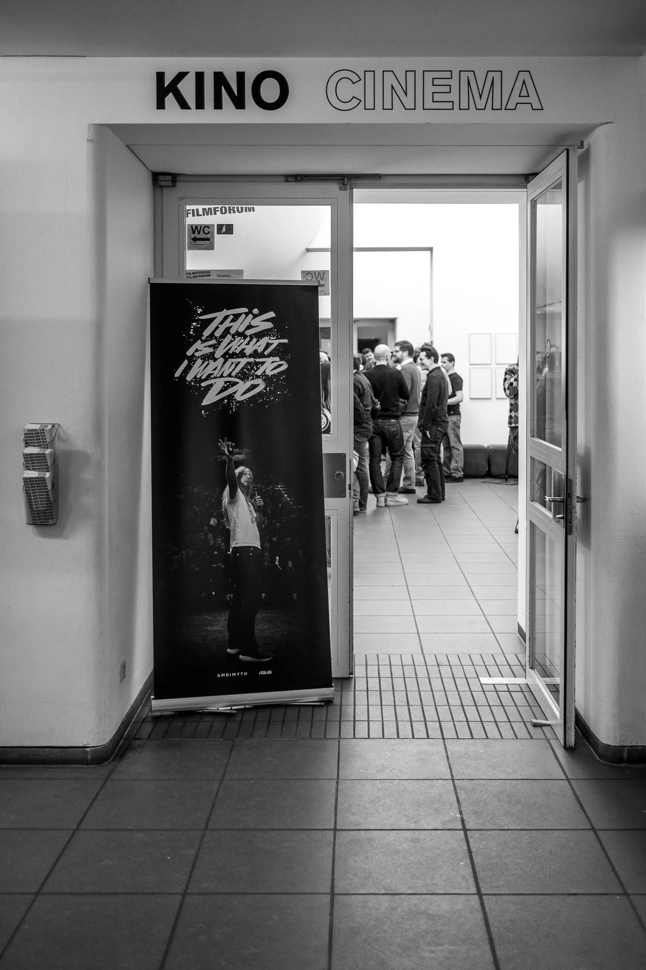 The open cinema doors under the KINO sign, the film’s roll-up banner just inside