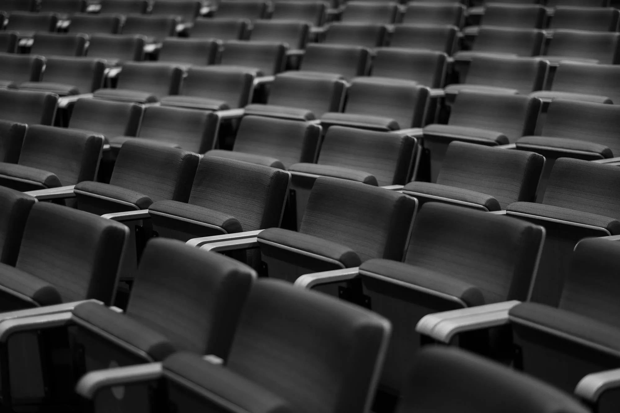 Empty seat rows close in the frame, seen low along their backs