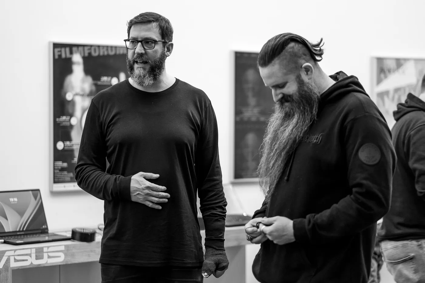 Two men in conversation in front of film posters in the foyer
