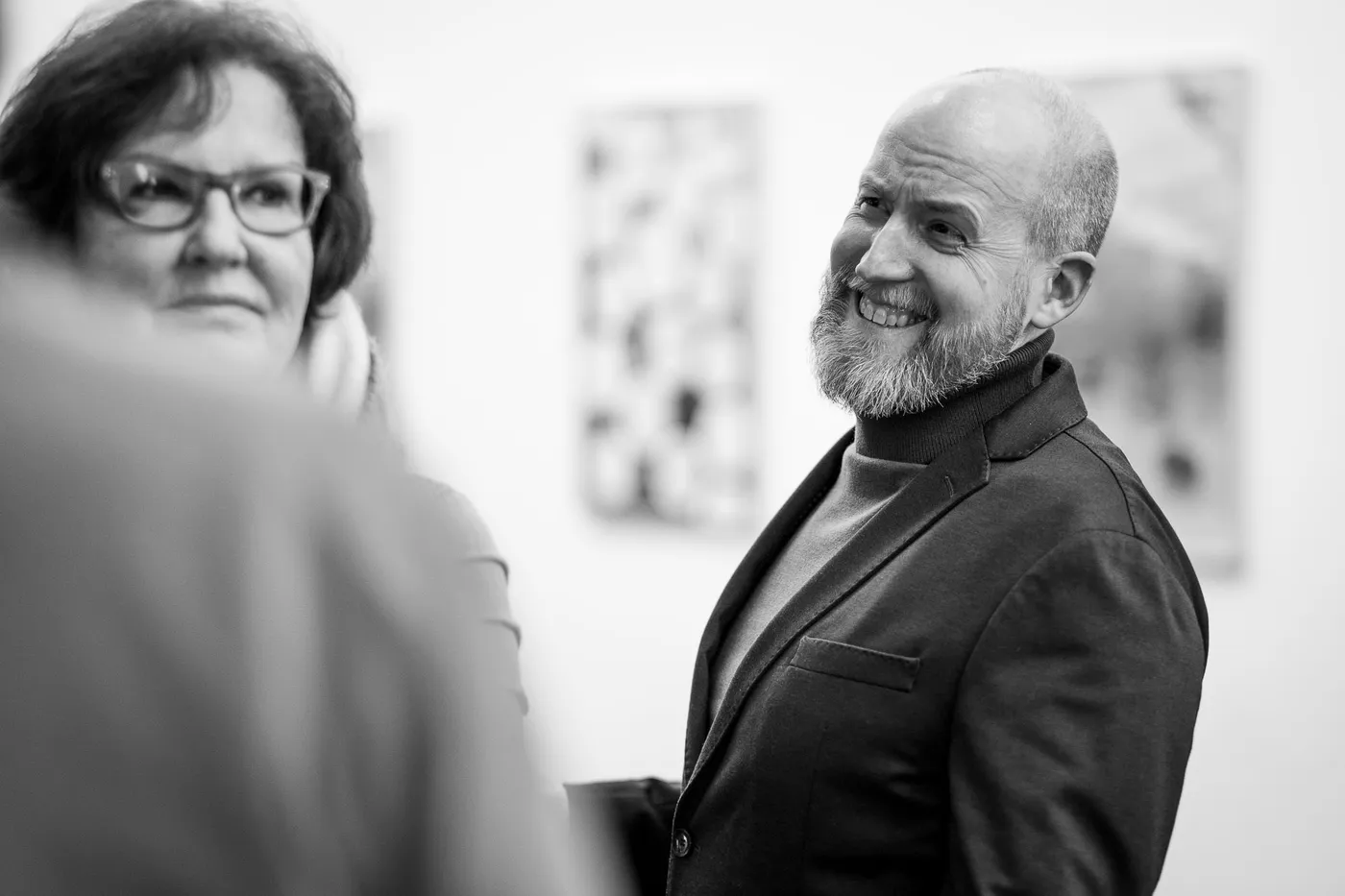 A smiling guest in the foyer, a team member beside her