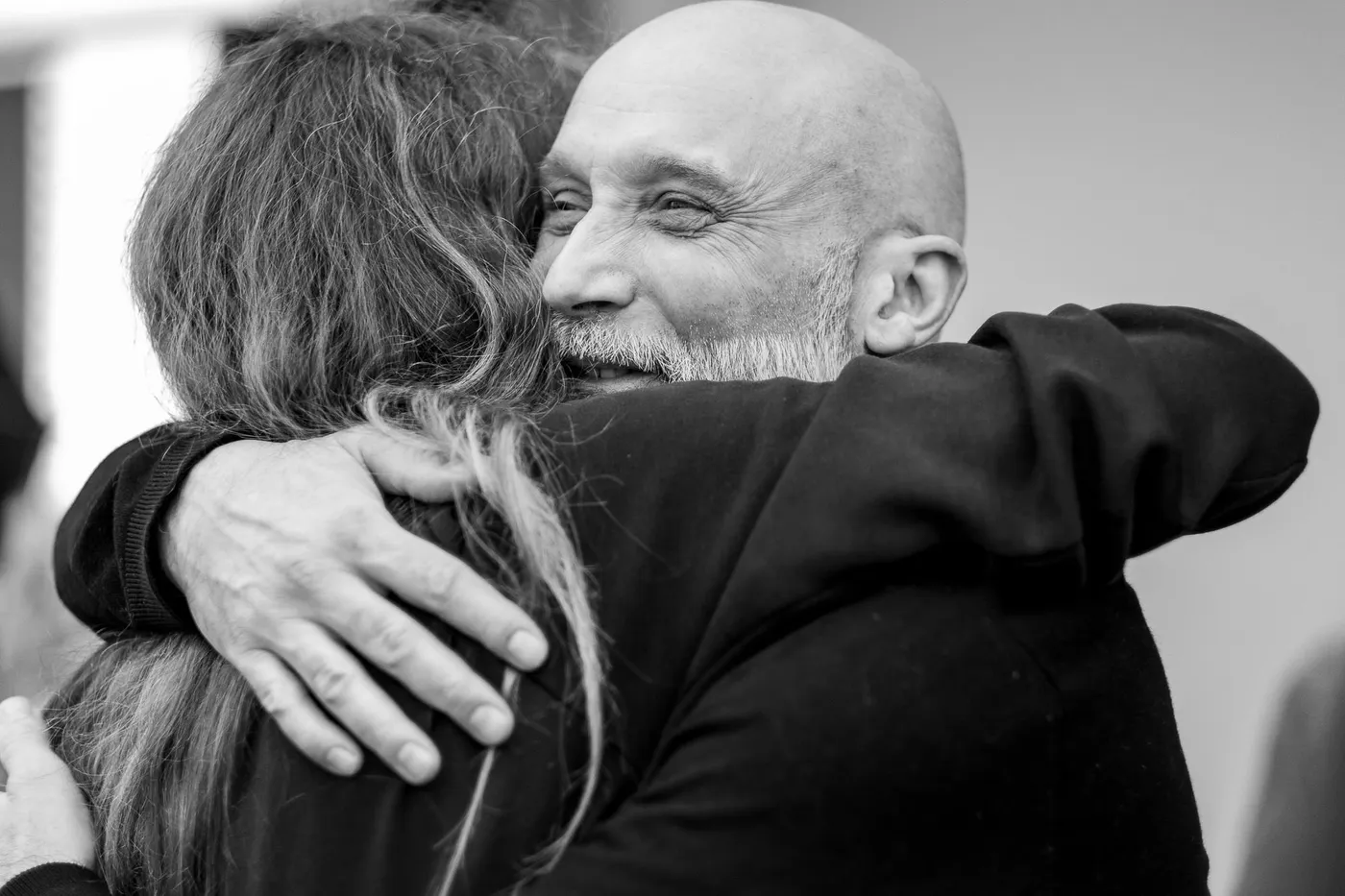 A warm hug between two guests in the foyer