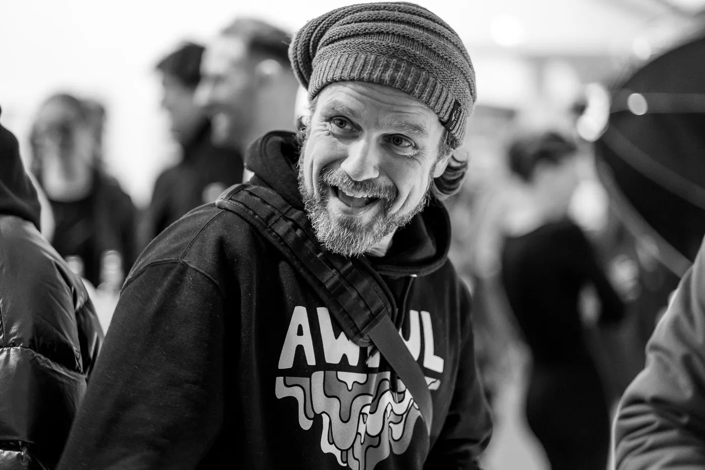 A guest in a knit hat turning to the camera with a grin
