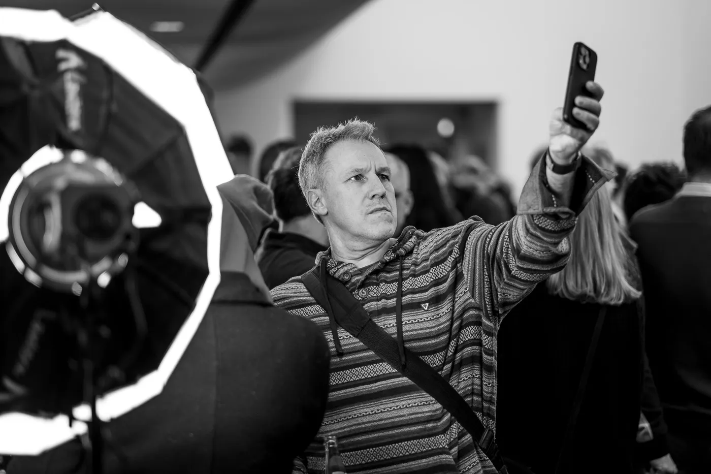 A guest filming on a phone next to a softbox light
