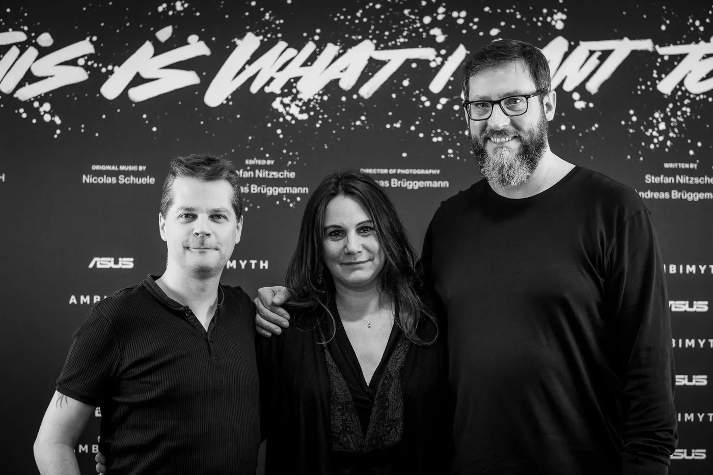 Three members of the team in front of the film’s lettering
