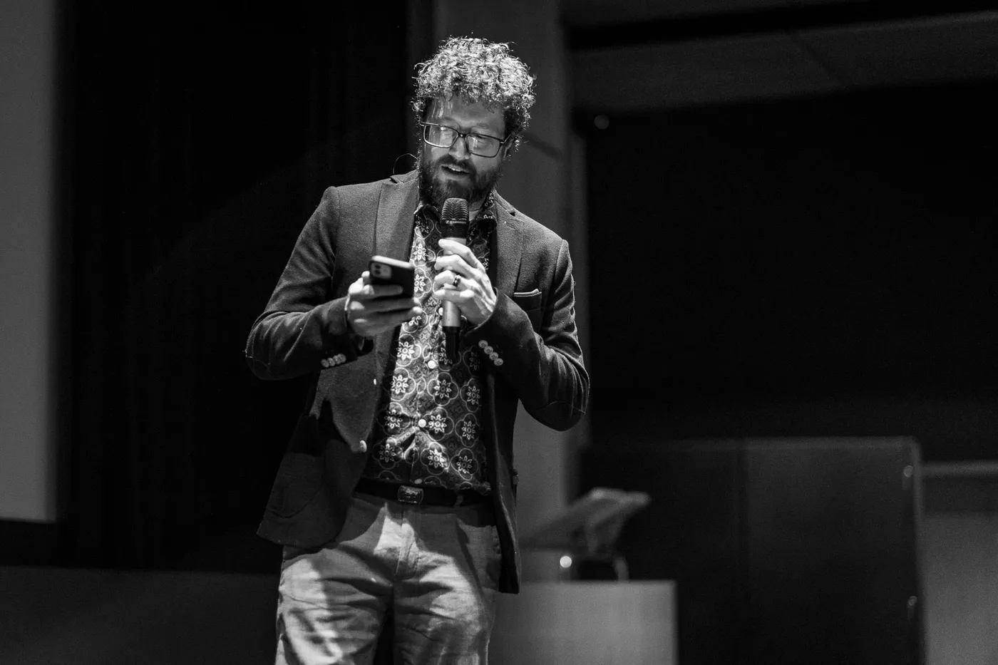 The host walking across the stage with a microphone