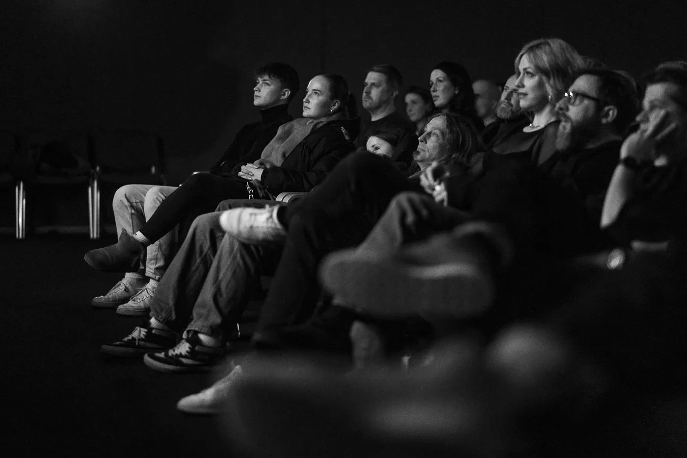 A row of the audience watching the screen in the dark