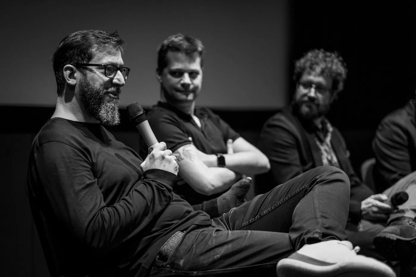 Three people on stage at the Q&A, one laughing into the microphone